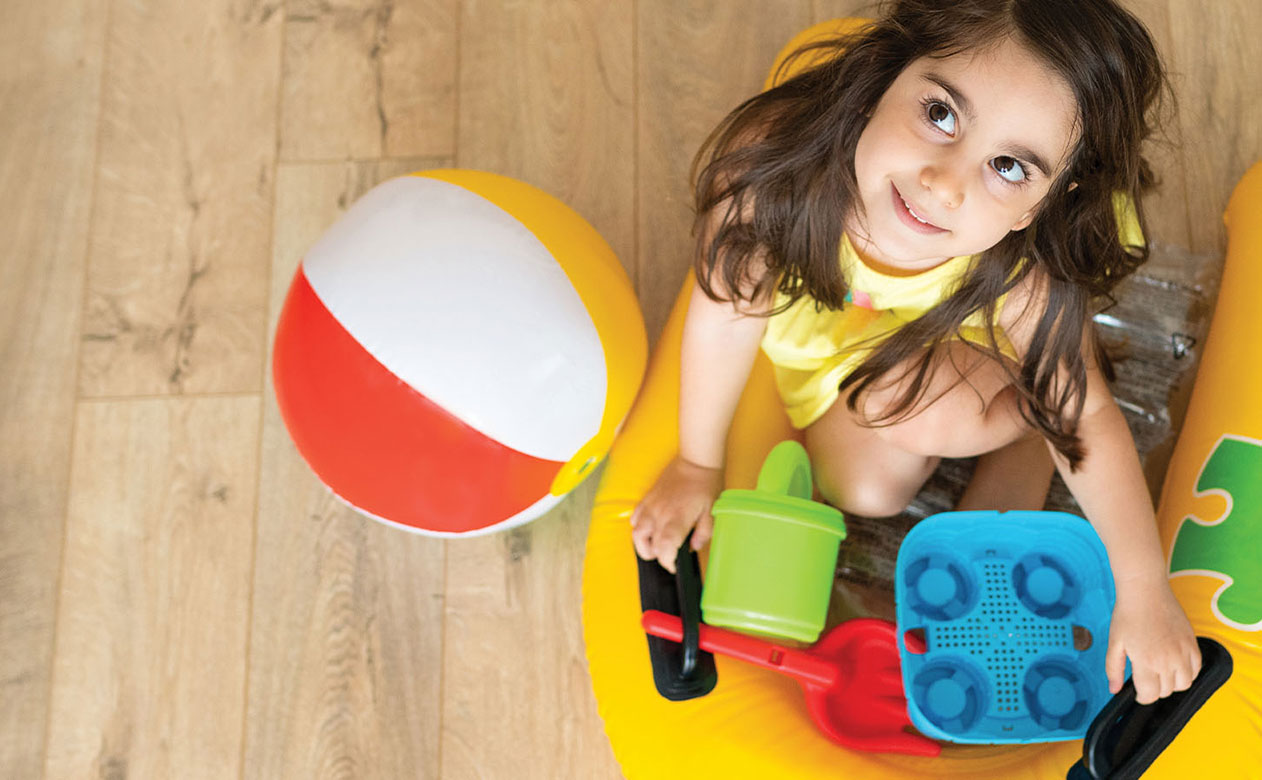Young girl playing with summer toys indoors